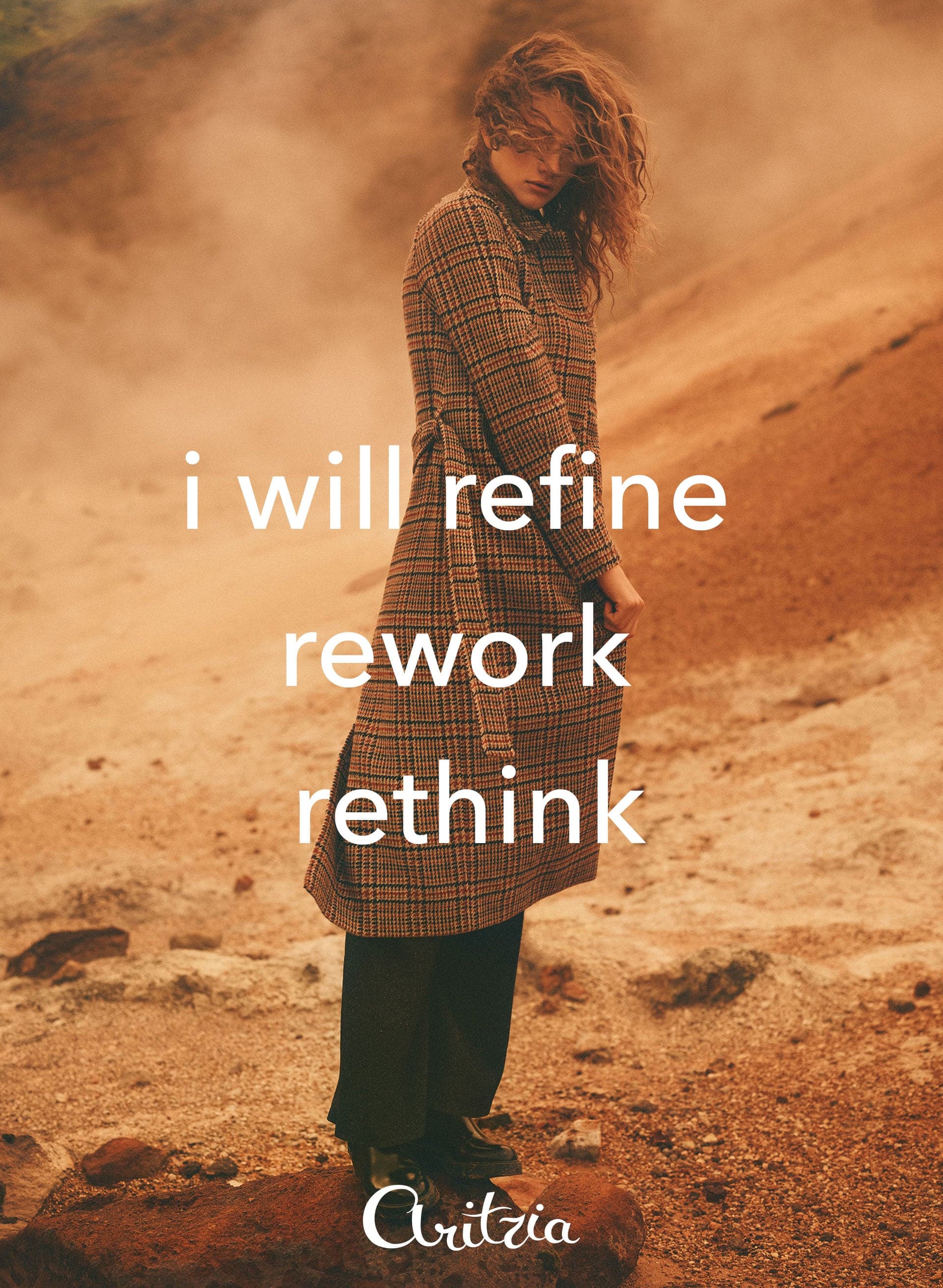 Model in a check coat on an orange hillside, “i will refine, rework, rethink”