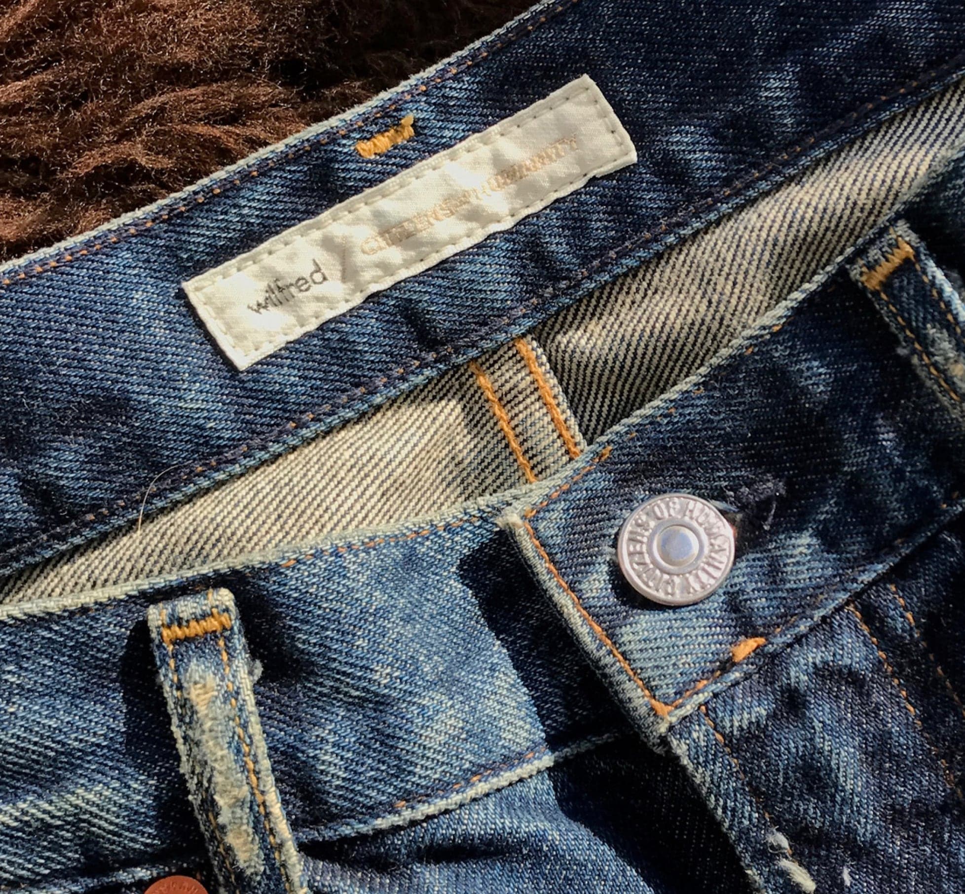 Waistband label and button on raw denim