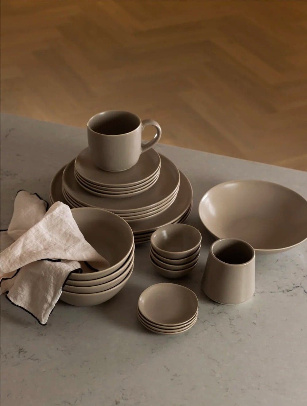 Set of taupe dinnerware with a linen napkin