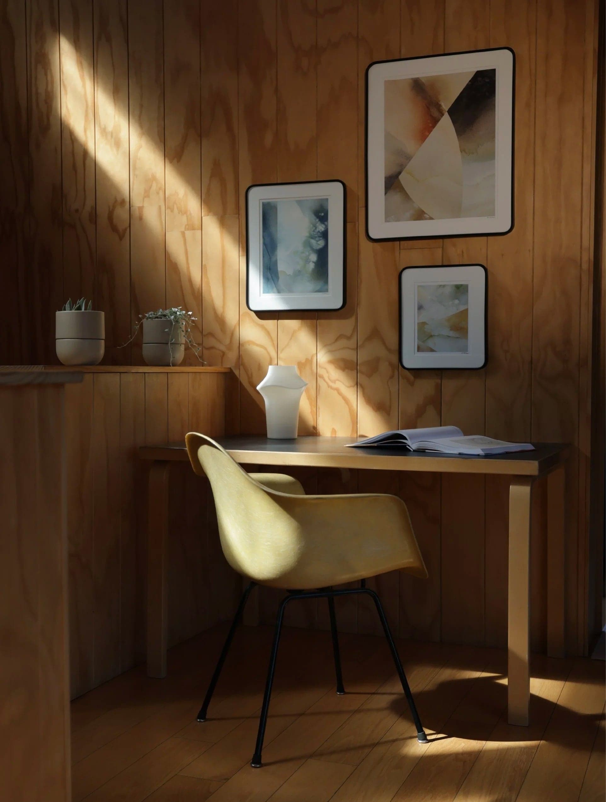 Sunlit desk with framed prints and the Fable lamp