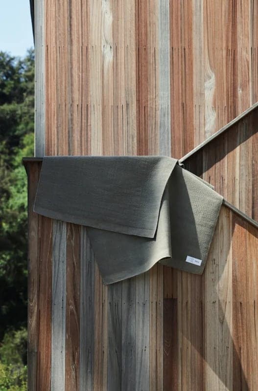 Throw hung over a weathered wooden railing