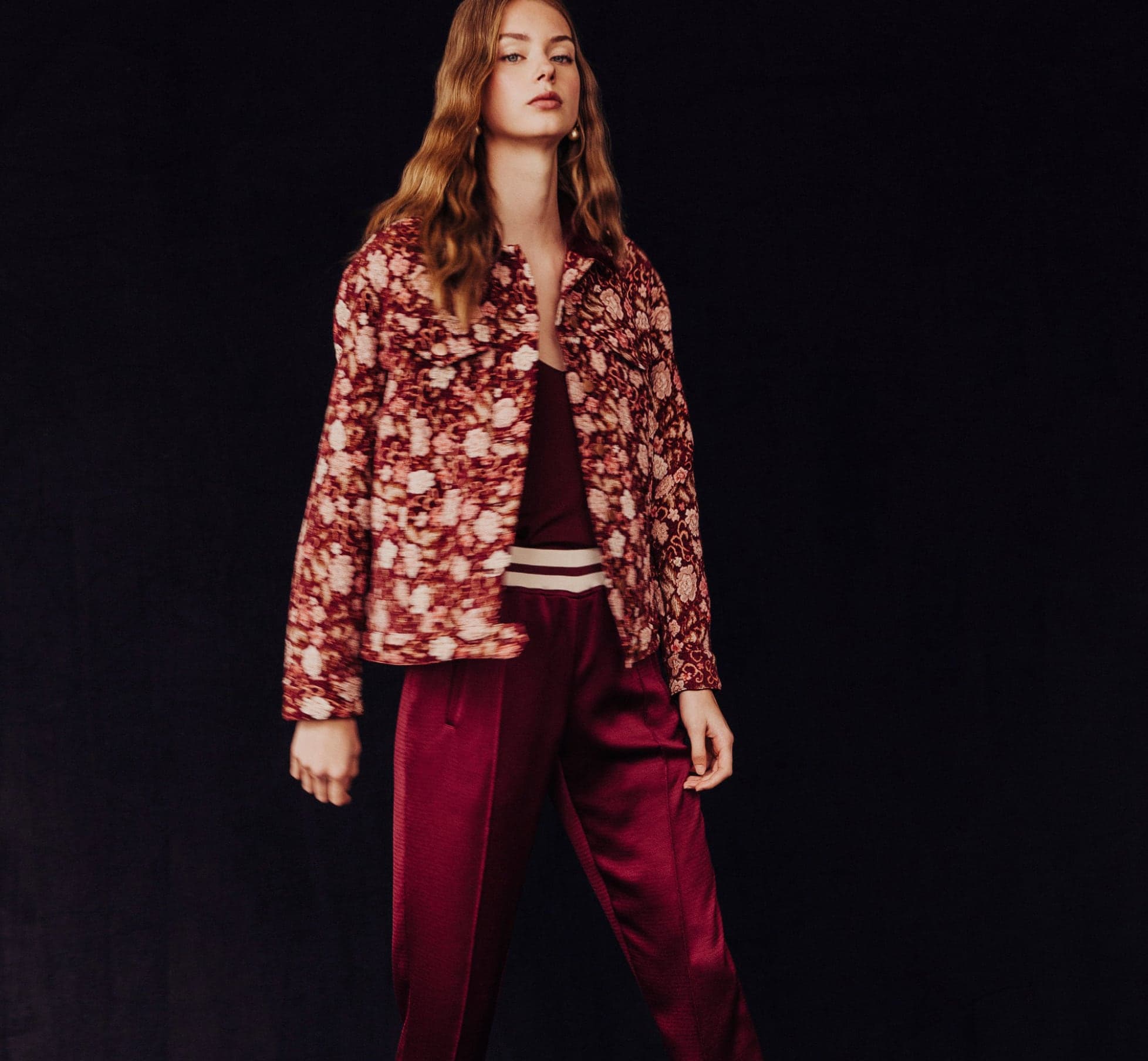 Model in a floral jacket and burgundy satin trousers