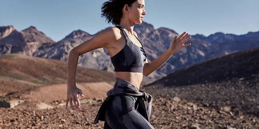 Runner in a camo sports bra against mountains