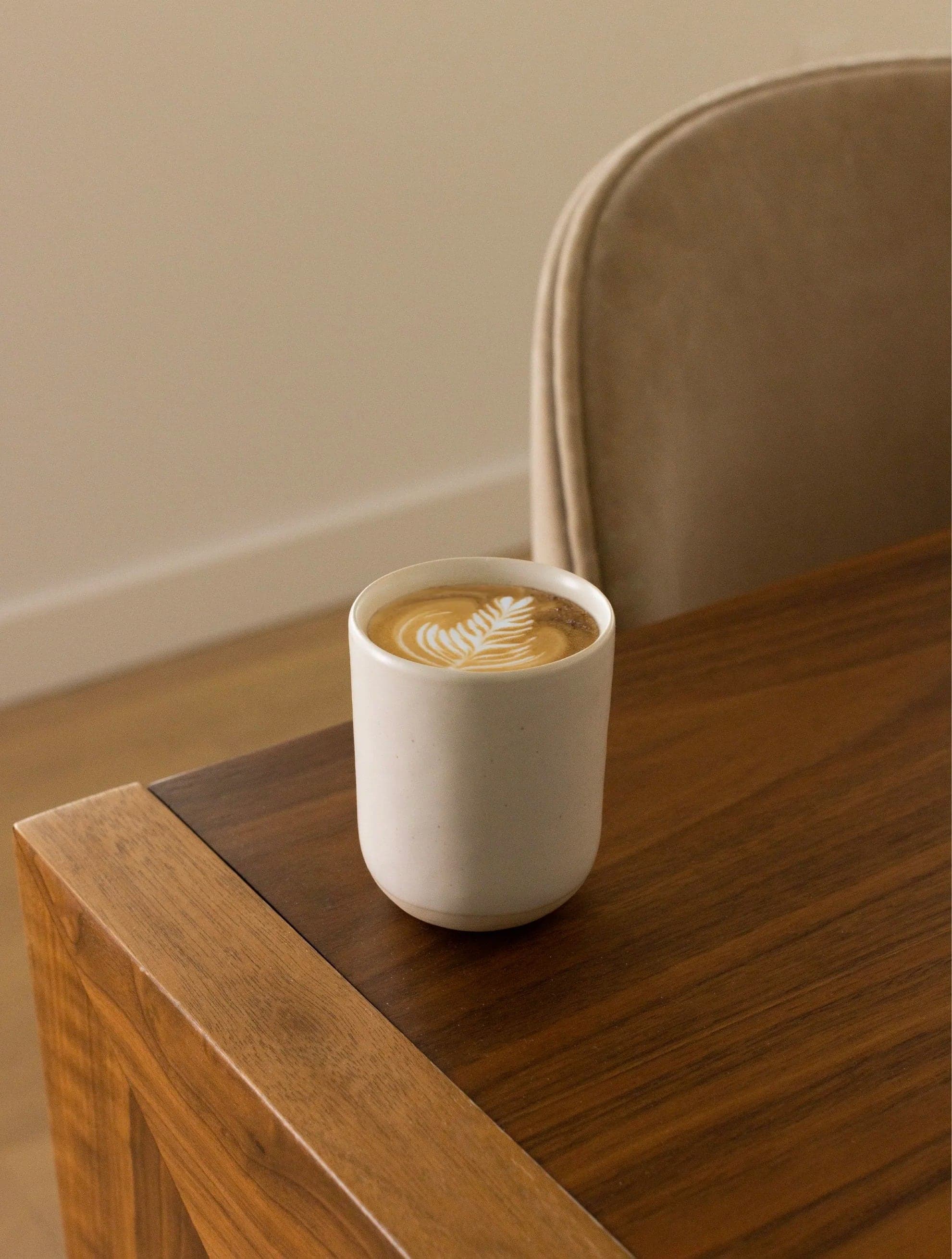 Latte in a Fable cup on a walnut table
