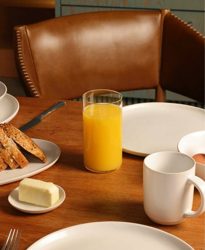 Breakfast table with orange juice, toast and Fable plates