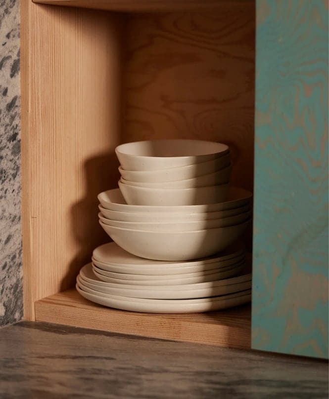 Stacked white bowls in a wooden cabinet