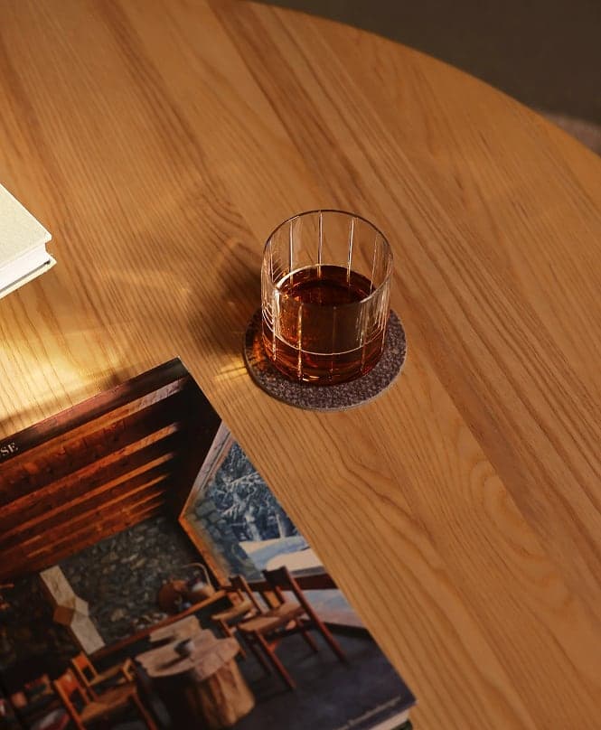Glass of whisky on a wooden table beside a magazine