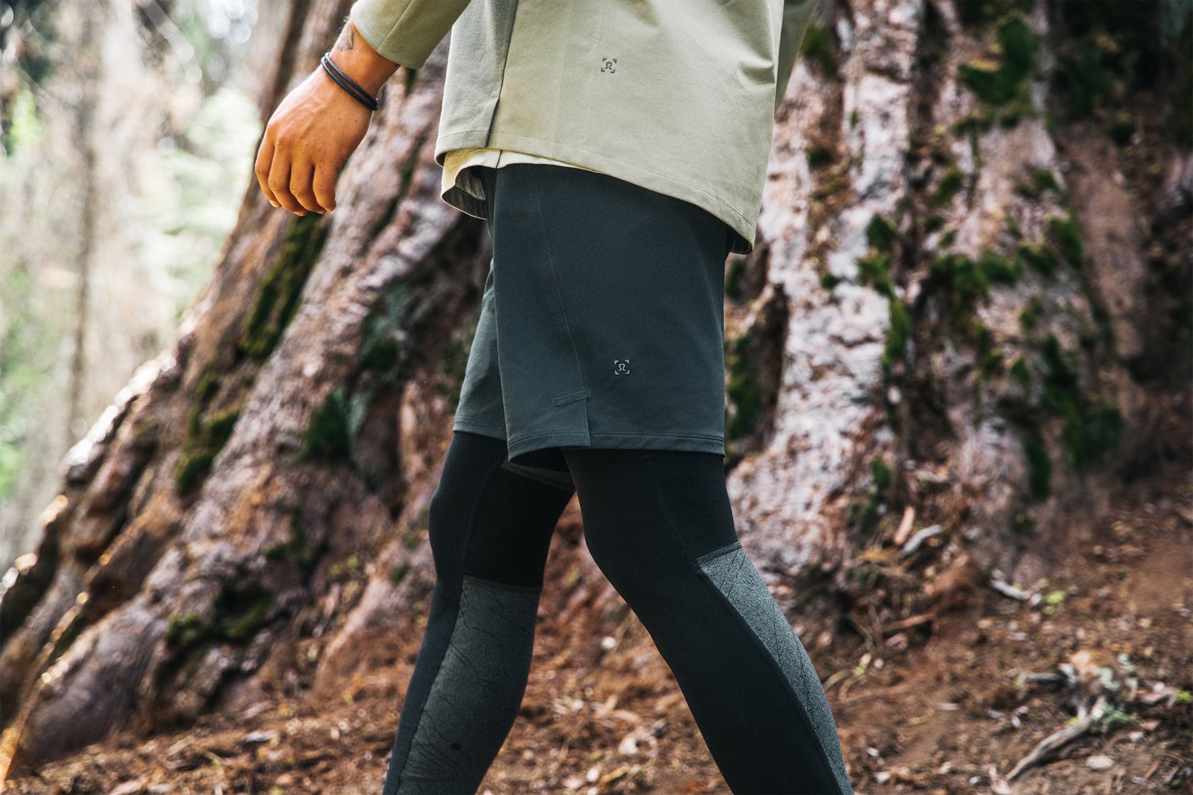 Close-up of shorts and tights mid-stride by a tree trunk